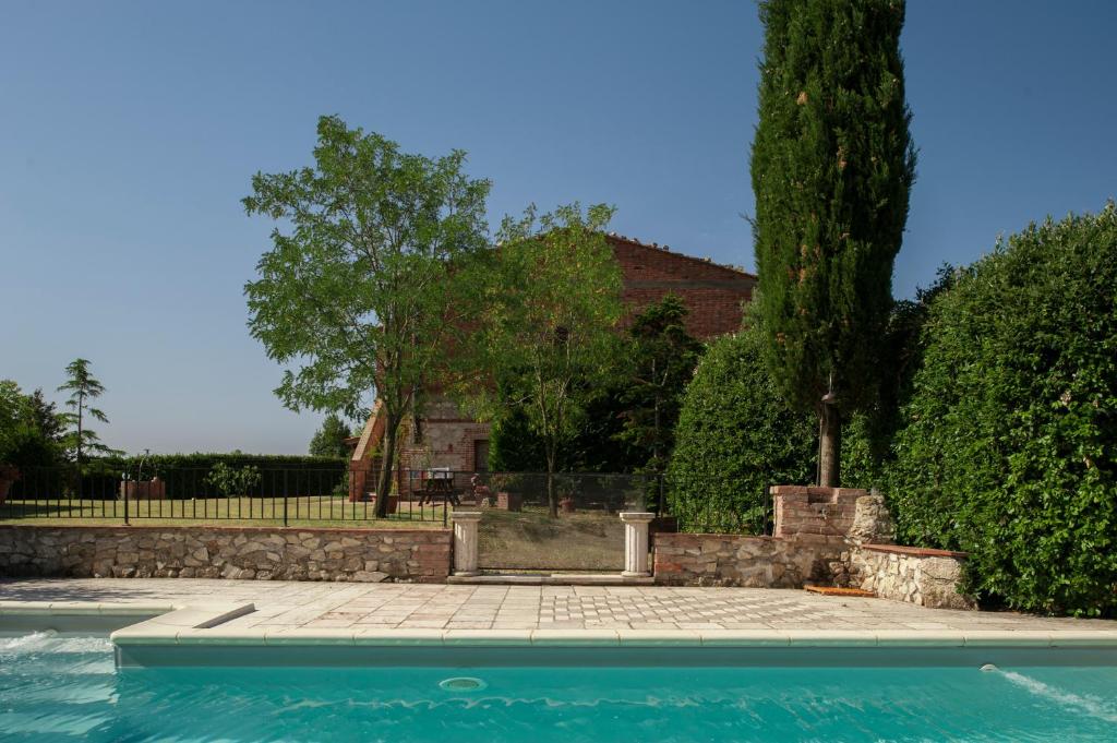 a swimming pool in front of a house at Agriturismo Podernuovo in Asciano
