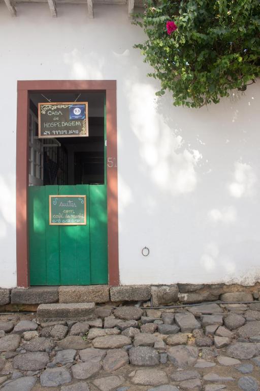 a green door on a white building with a sign at Casa de Hospedagem Paraty in Paraty
