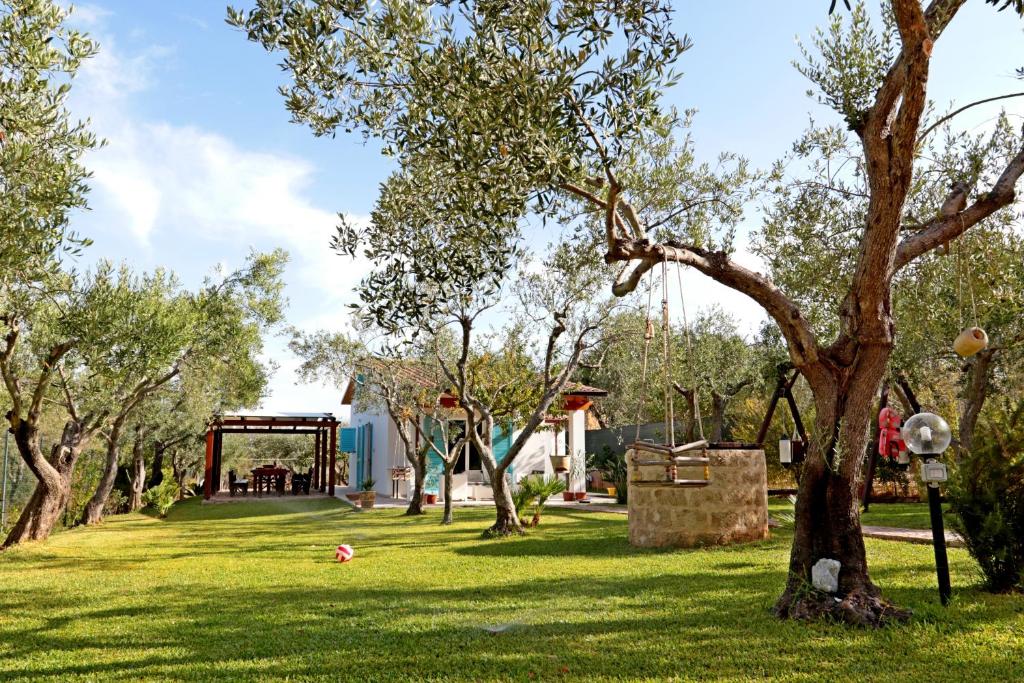 un parc avec des arbres et une aire de jeux au loin dans l'établissement Giovanni House, à Alghero
