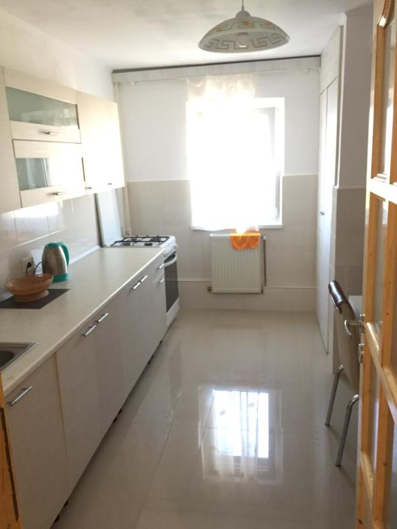 una cucina con armadietti bianchi e una finestra di 3 rooms ApartHotel a Braşov