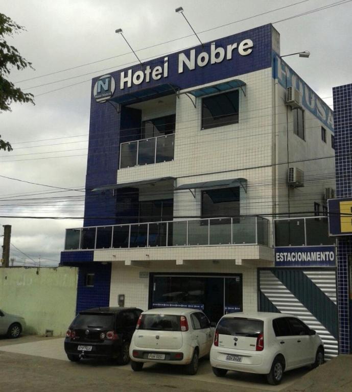 two cars parked in front of a hotel norride at Hotel Nobre in Senhor do Bonfim