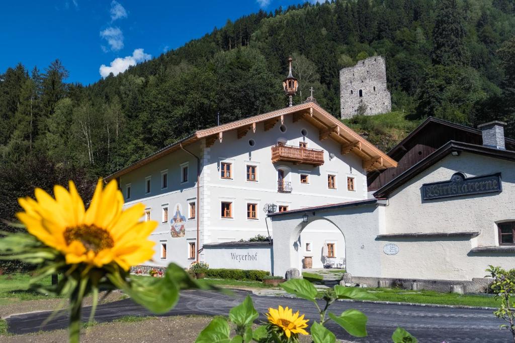 a building with a sunflower in front of it at Gasthof Weyerhof in Bramberg am Wildkogel