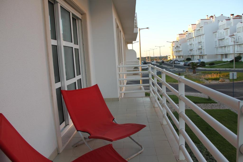 バレアルにあるBaleal Holidays - Sol Vilage 2 BALEAL - CIMAの建物のバルコニーに座る赤い椅子2脚