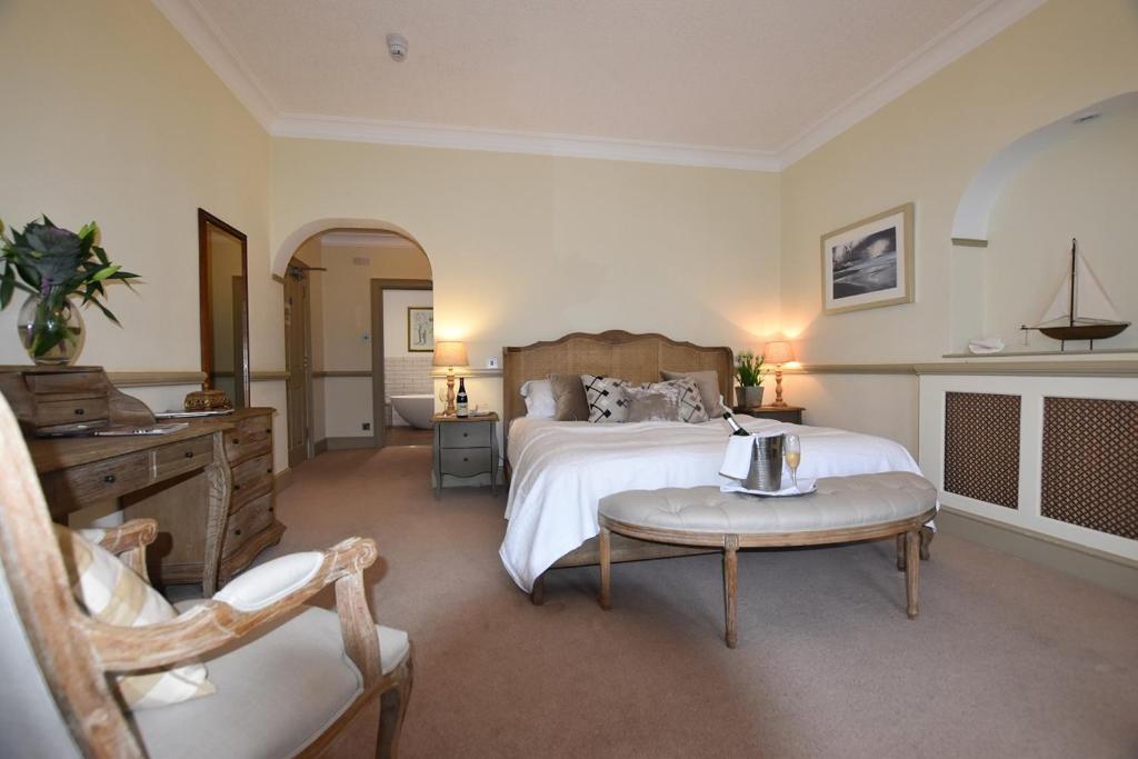 a large bedroom with a bed and a table at Watersmeet Hotel in Woolacombe