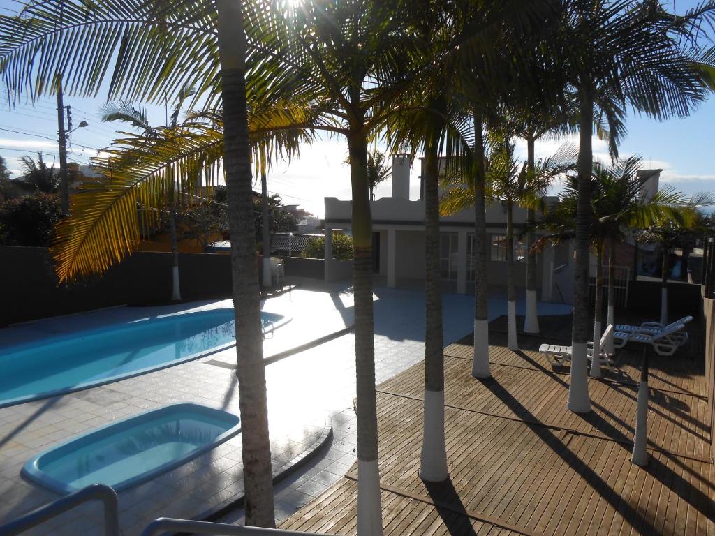 uma vista a partir da varanda de um resort com palmeiras em Apartamento Santinho em Florianópolis