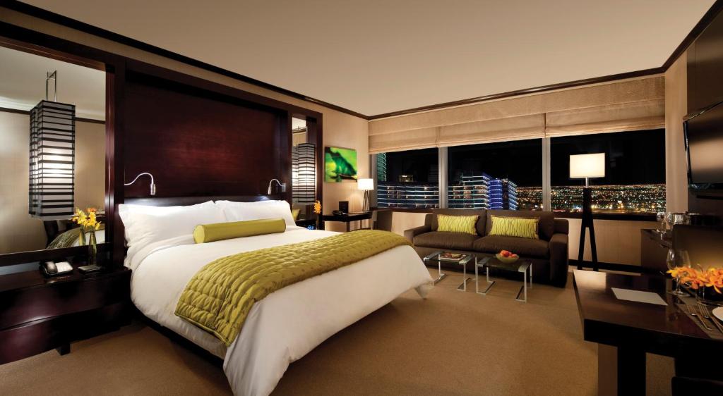 a bedroom with a large bed and a living room at Luxury Suites International at Vdara in Las Vegas