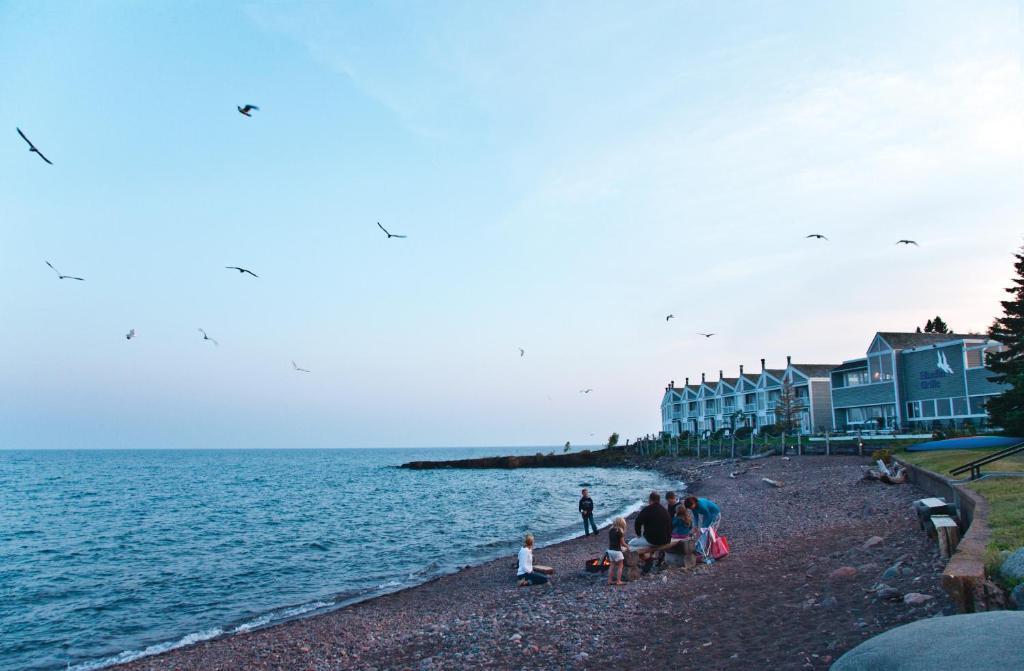 a group of people on a beach near the water at Bluefin Bay on Lake Superior in Tofte