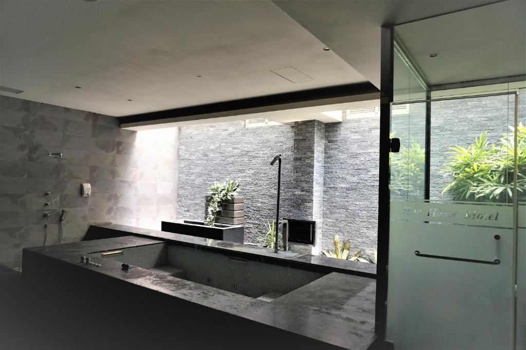 baño con lavabo y ventana grande en Her Home Spa Motel Xinying, en Xinying