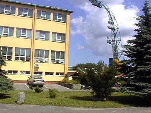 un grand bâtiment avec une voiture garée devant lui dans l'établissement Hotel Štadión, à Košice