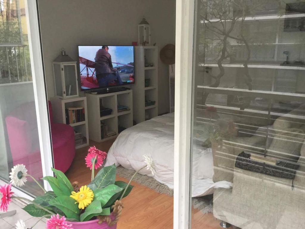 uma sala de estar com televisão e uma cama em Araoz 2055 em Buenos Aires
