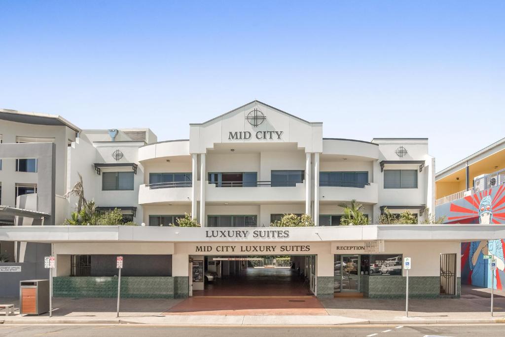 um grande edifício branco com entrada frontal para uma suite de luxo em Mid City Luxury Suites em Cairns