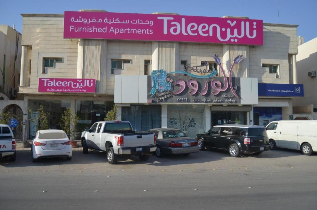a group of cars parked in front of a building at Taleen Al Nakheel Apartment in Riyadh