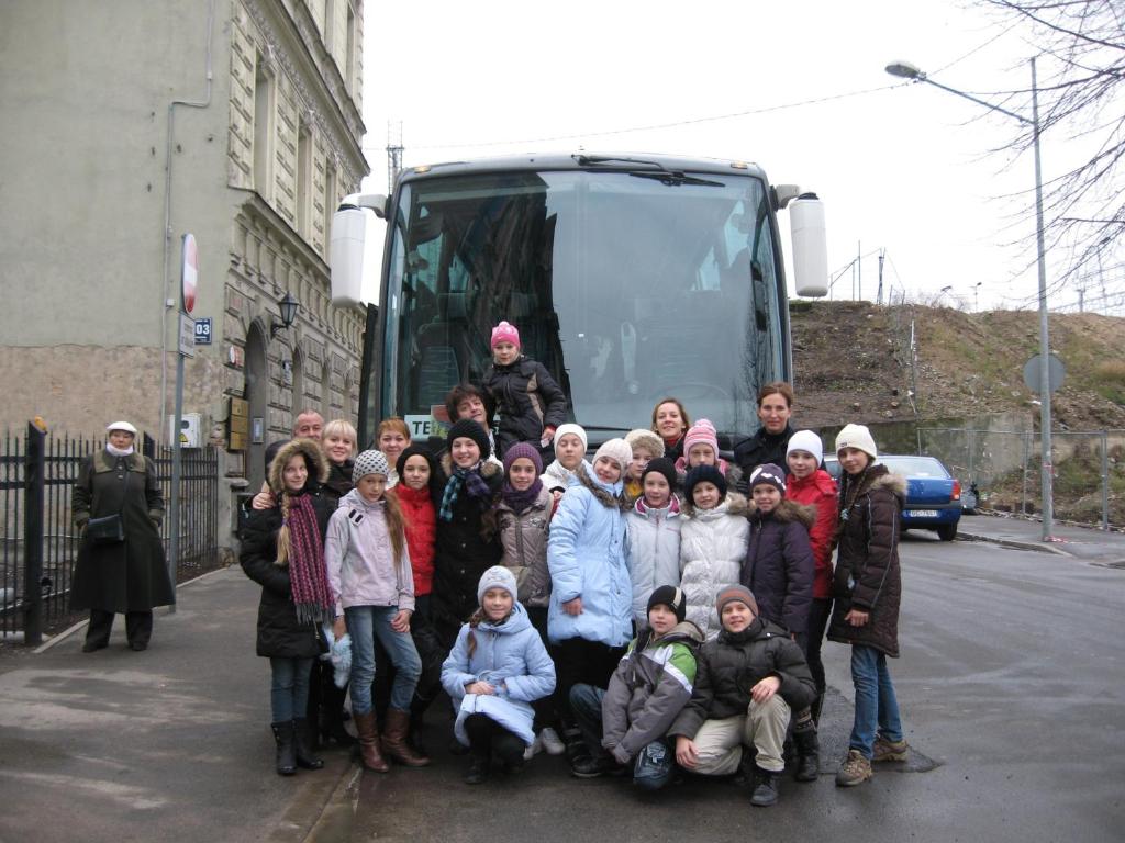 un gruppo di persone che si trovano di fronte a un autobus di Central Park Rooms a Riga