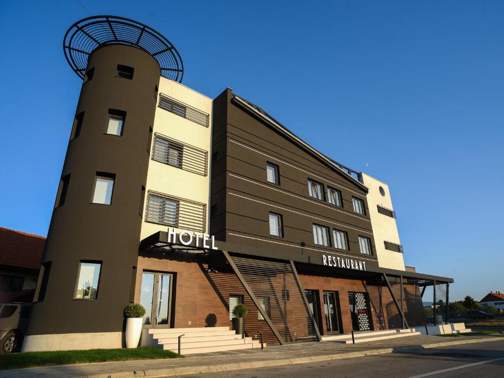 a hotel with a tower in front of a building at Hotel Ideo Lux in Niš