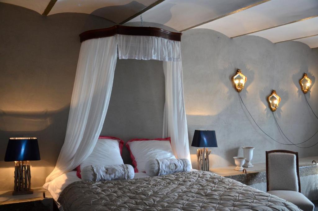 ein Schlafzimmer mit einem großen Bett mit Baldachin in der Unterkunft B&B La ferme du doux in Libramont