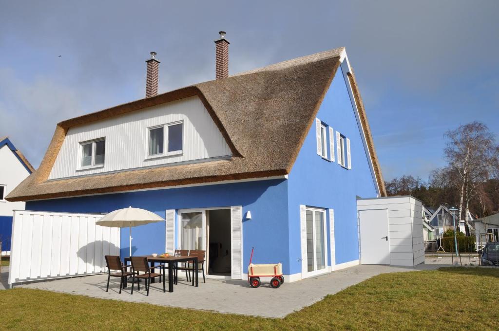 a blue and white house with a table and chairs at Ferienhaus Wiekhus in Breege