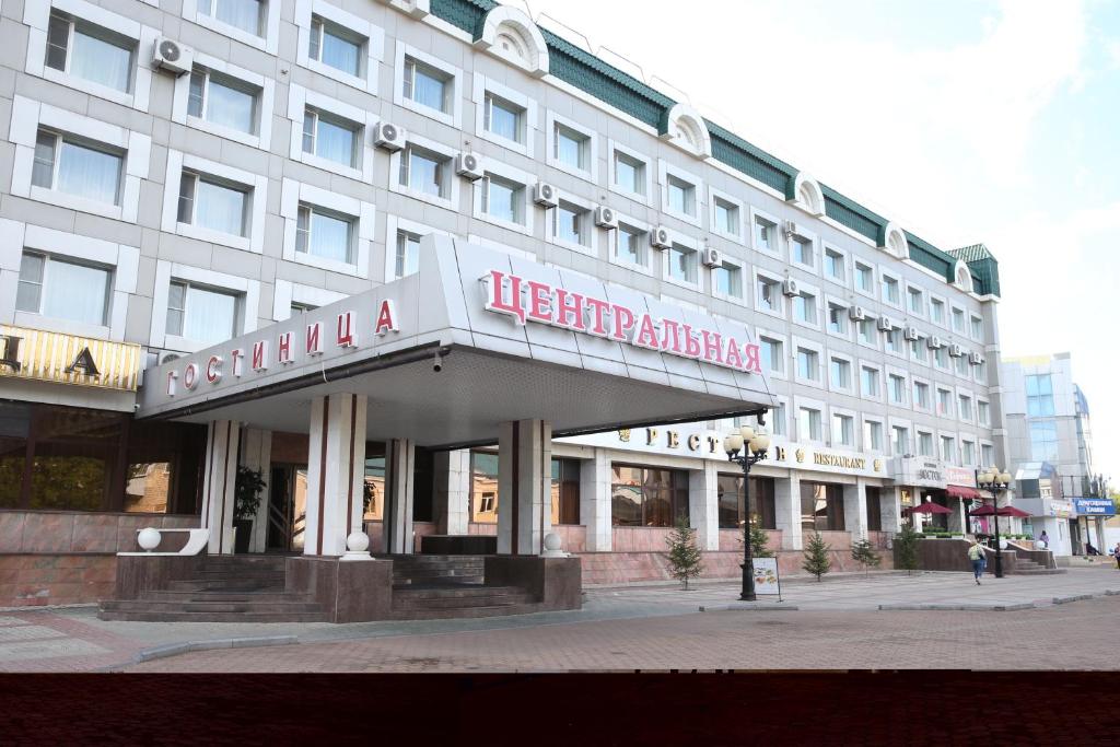 un gran edificio blanco con un cartel. en Hotel Central (Vostok), en Birobidzhan