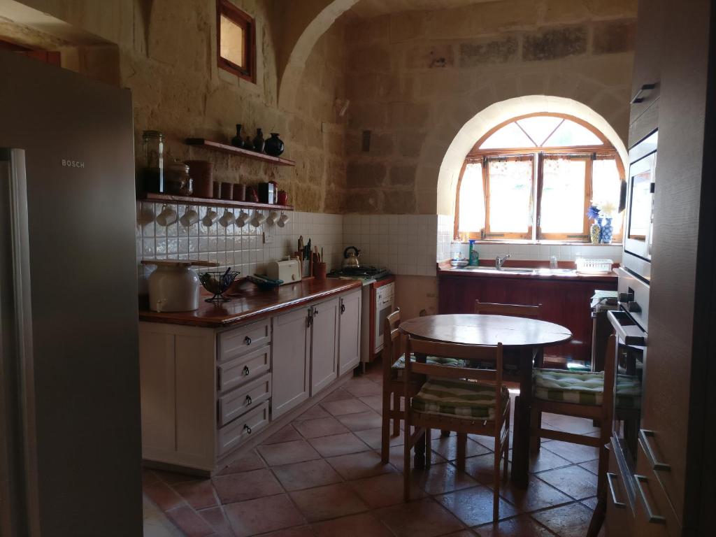 uma cozinha com uma mesa e uma janela em Farmhouse Dhyana em Għasri