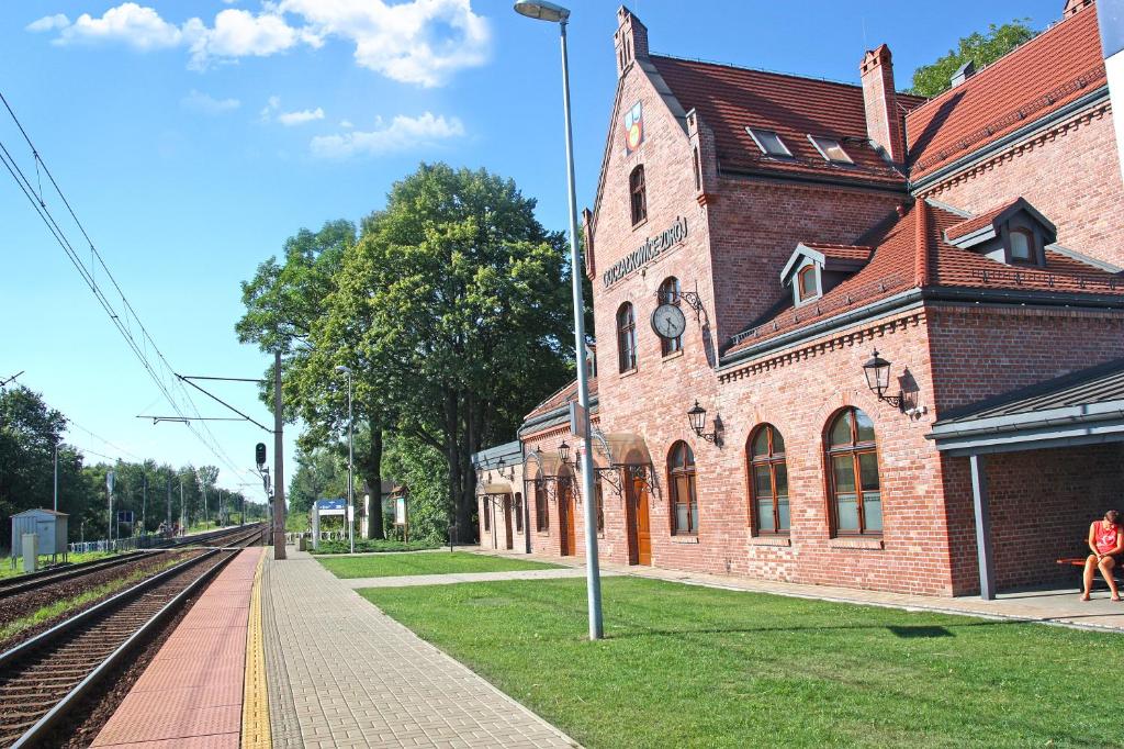 a train station with a brick building next to the tracks at Apartament na Starym Dworcu in Goczałkowice-Zdrój