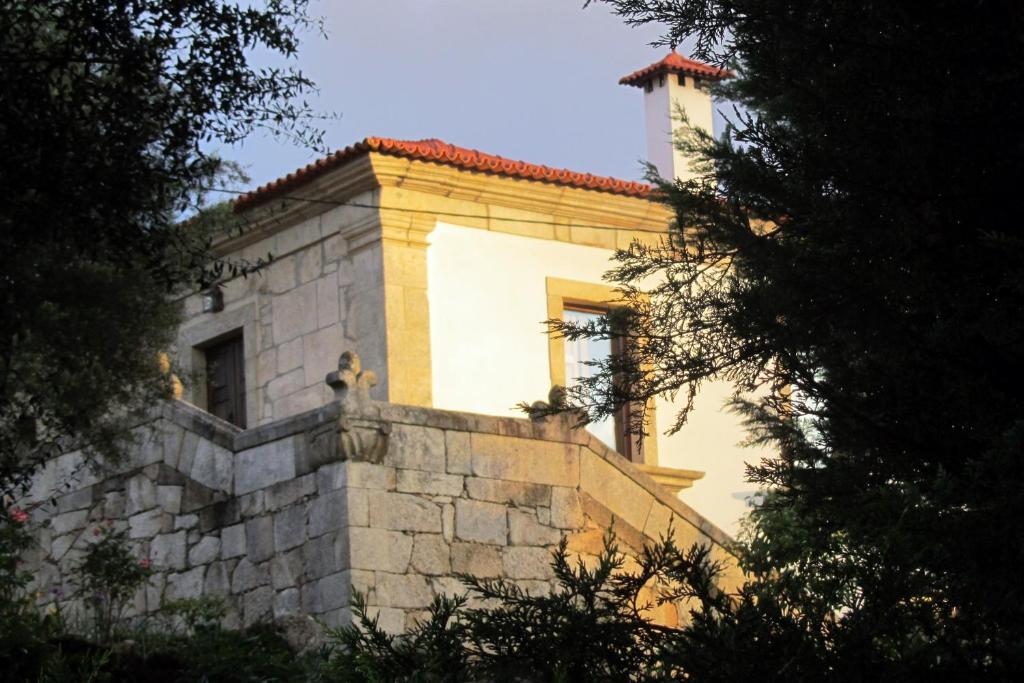 um edifício com uma torre no topo de uma parede de pedra em Casa Dalevada, Veade em Celorico de Basto