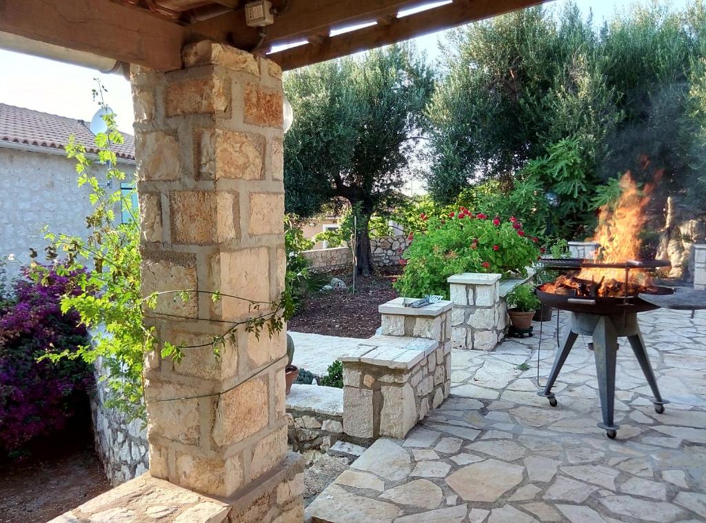 a patio with a grill and a fire place at Federico Villa in Khalikerí