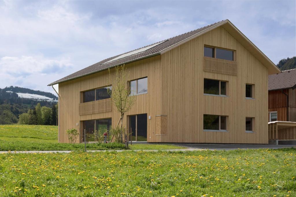シュヴァルツェンベルク・イム・ブレゲンツァーヴァルトにあるFerienwohnung Wertvollholzhausの草原の大木造家屋