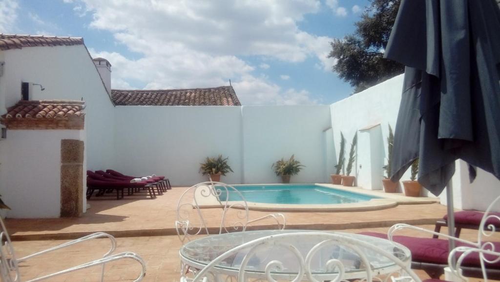 un patio con piscina, mesa y sillas en El Aleznal, en Trujillo