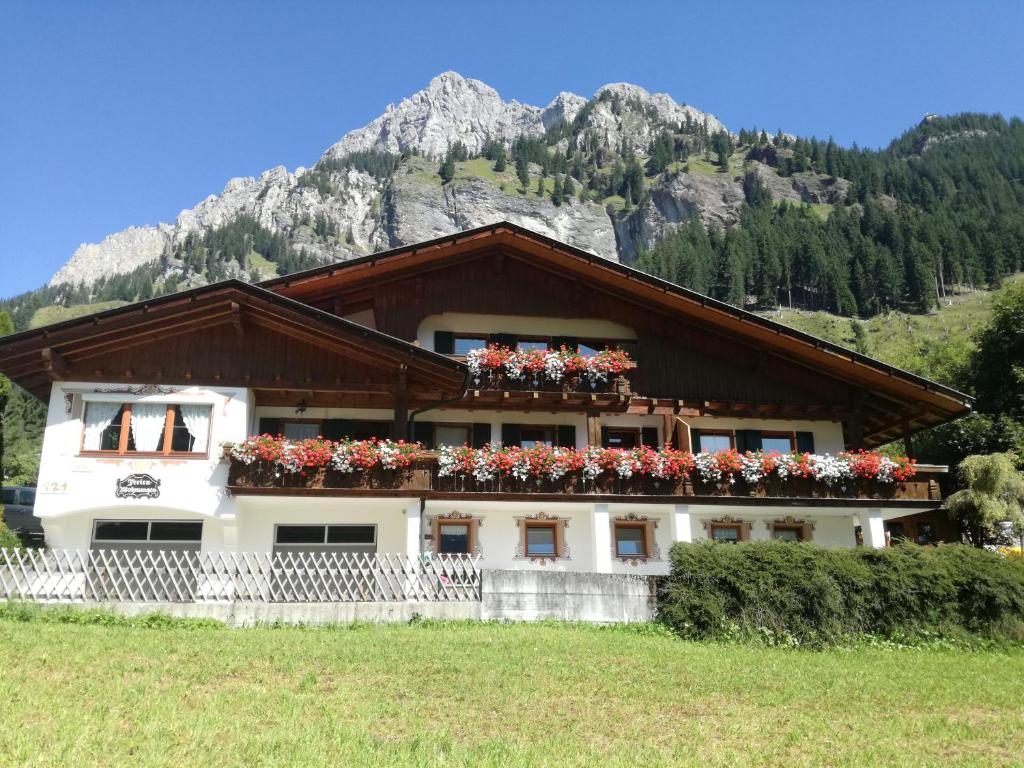 a building with flower boxes on it in front of a mountain at Haus Monika in Nesselwängle