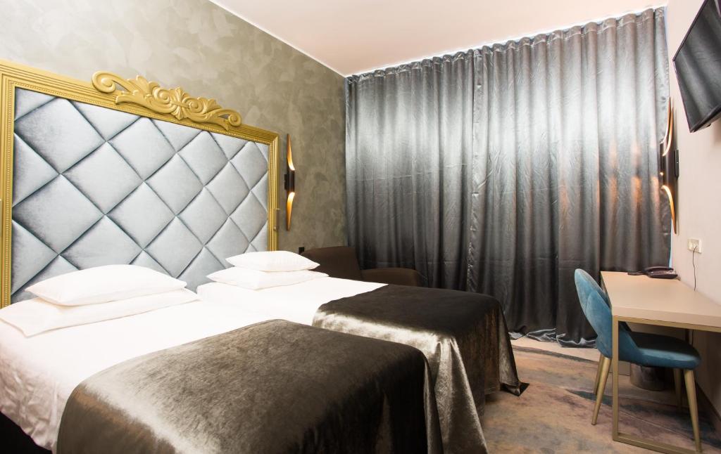 um quarto de hotel com duas camas e uma secretária em Aqva Hotel & Spa em Rakvere
