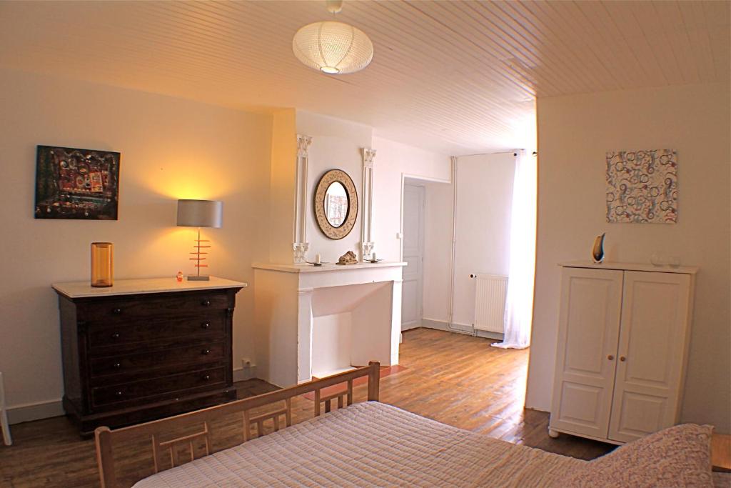 a living room with a bed and a dresser and a mirror at Chambres d'hôtes La Luciole in Tourtrol