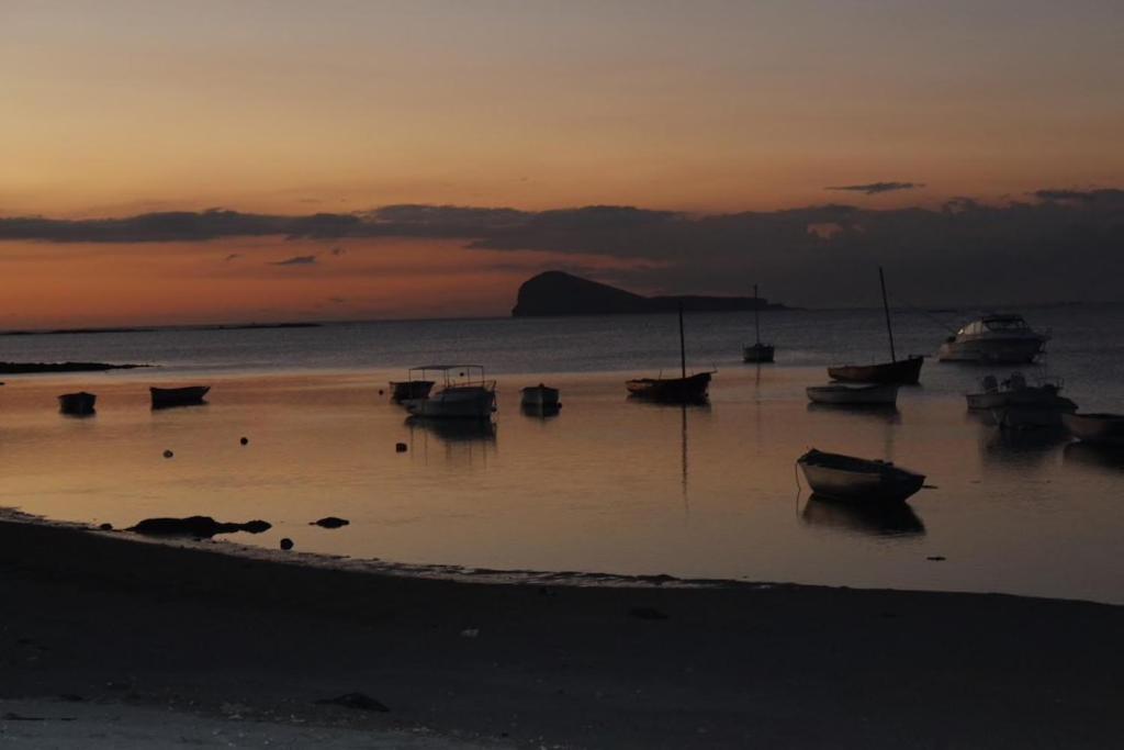 un grupo de barcos sentados en la playa al atardecer en Whynot Mauritius, en Grand Gaube