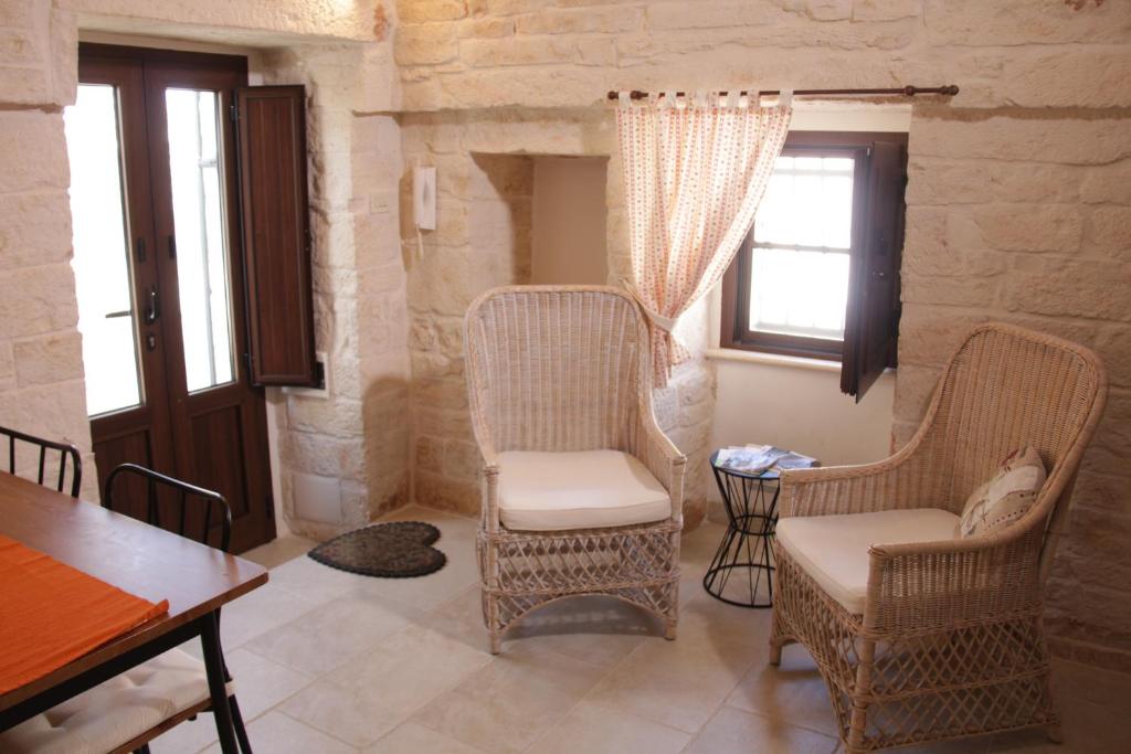 a living room with two chairs and a table at il trullo di giada e mattia in Alberobello