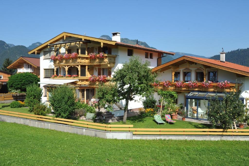 ein großes Haus mit Blumenkästen auf den Balkonen in der Unterkunft Haus Unterberg in Kössen