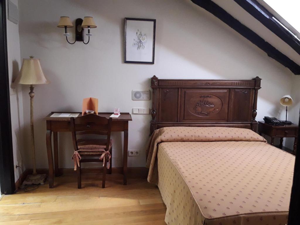 a bedroom with a bed and a desk and a table at Hotel La Posada Regia in León