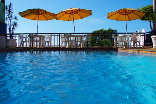 einen Pool mit Stühlen und Sonnenschirmen sowie eine Schwimmpoolasteryastery in der Unterkunft Pousada da Memeia in Iriri