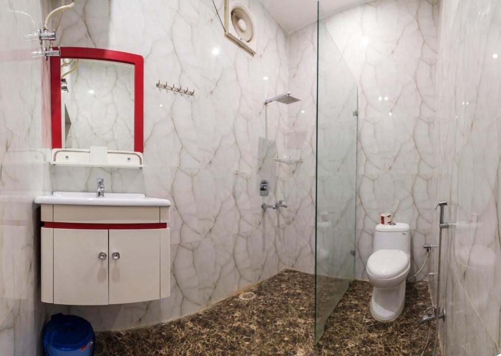Un baño con inodoro y ducha de cristal. en Tuk Tuk Homestay, en Agra