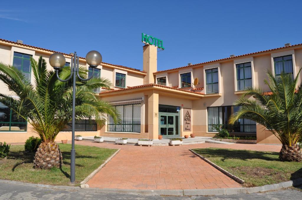 a large building with a clock on the front of it at Hotel Alonso de Monroy in Belvis de Monroy