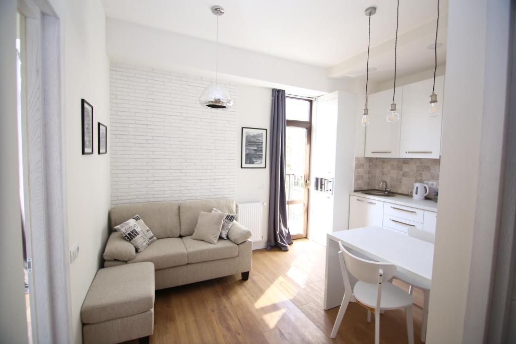 een witte woonkamer met een bank en een tafel bij Avlabari Apartment in Tbilisi City