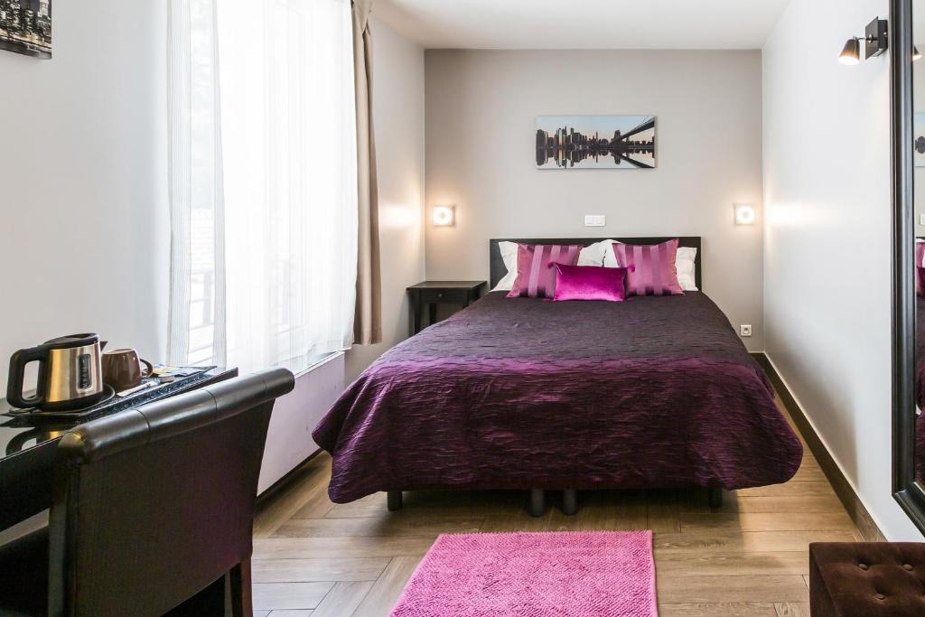 a bedroom with a large bed with pink pillows at Le Figuier in Ivry-sur-Seine