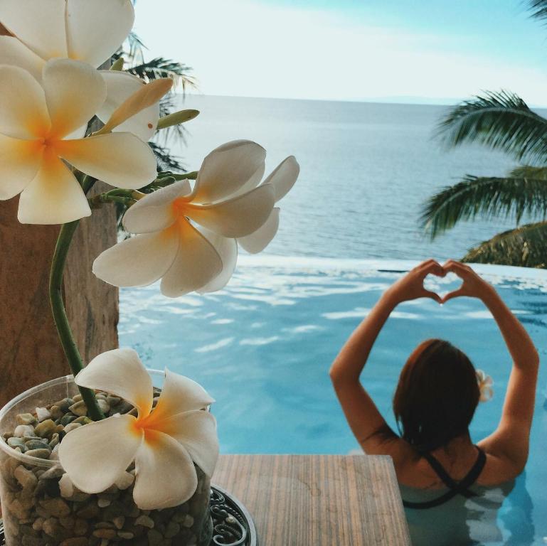 una mujer sentada en una piscina haciendo una forma de corazón en Bintana Sa Paraiso en Mambajao