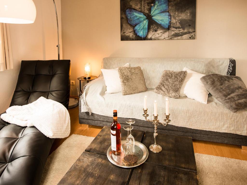 uma sala de estar com uma cama e uma mesa com bebidas em Ferienwohnung am Weissen Hirsch em Dresden