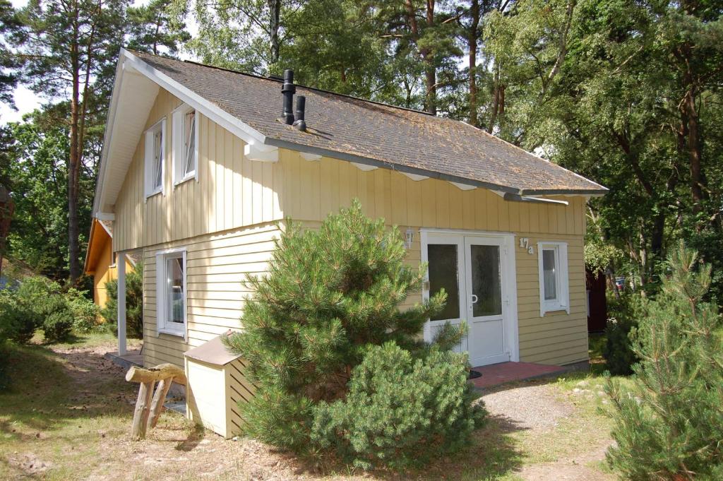 a small yellow house with a white door at Strandhaus Dünenweg 17a in Baabe