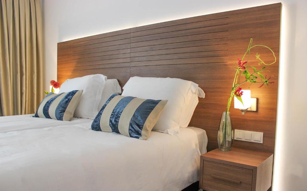 a bedroom with a large bed with a wooden headboard at A-Hotel Oosterhout in Oosterhout