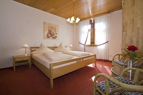 a bedroom with a bed and two chairs and a window at Ferienhaus Erich Bremm mit Moselblick in Neef