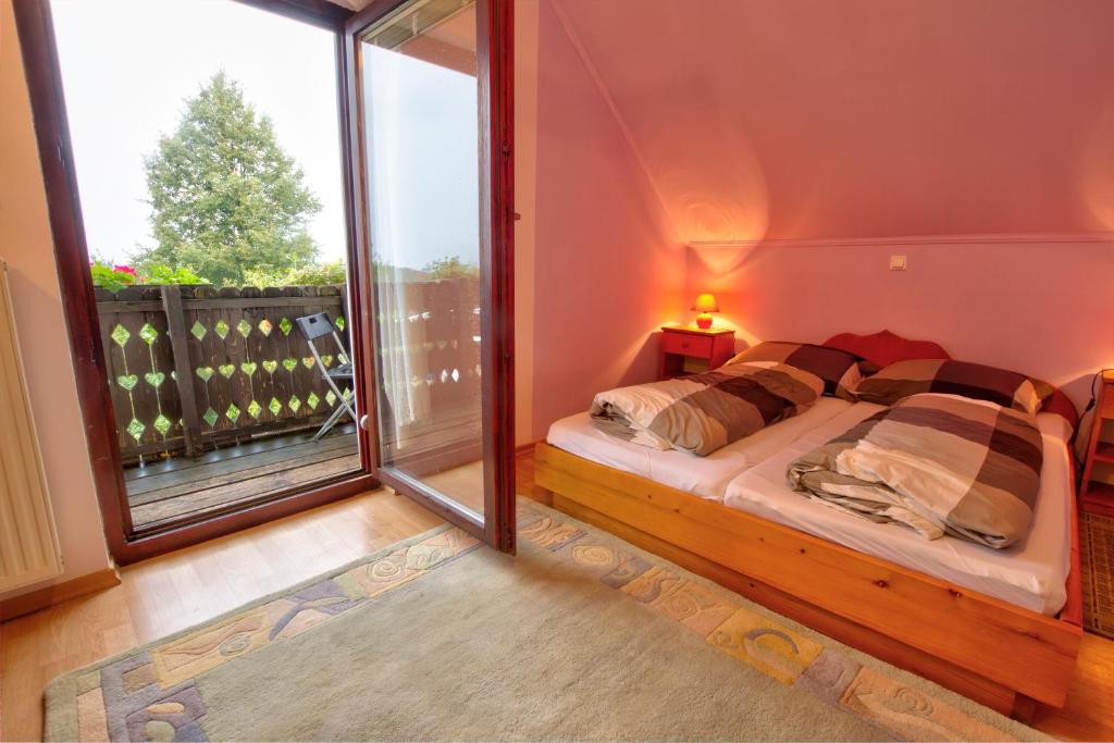 a bedroom with a bed and a large window at Country House Slemenšek in Vojnik