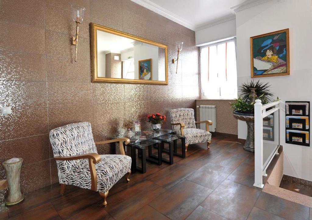 フィゲイラ・ダ・フォズにあるHotel Avizのテーブル、椅子、鏡が備わる客室です。