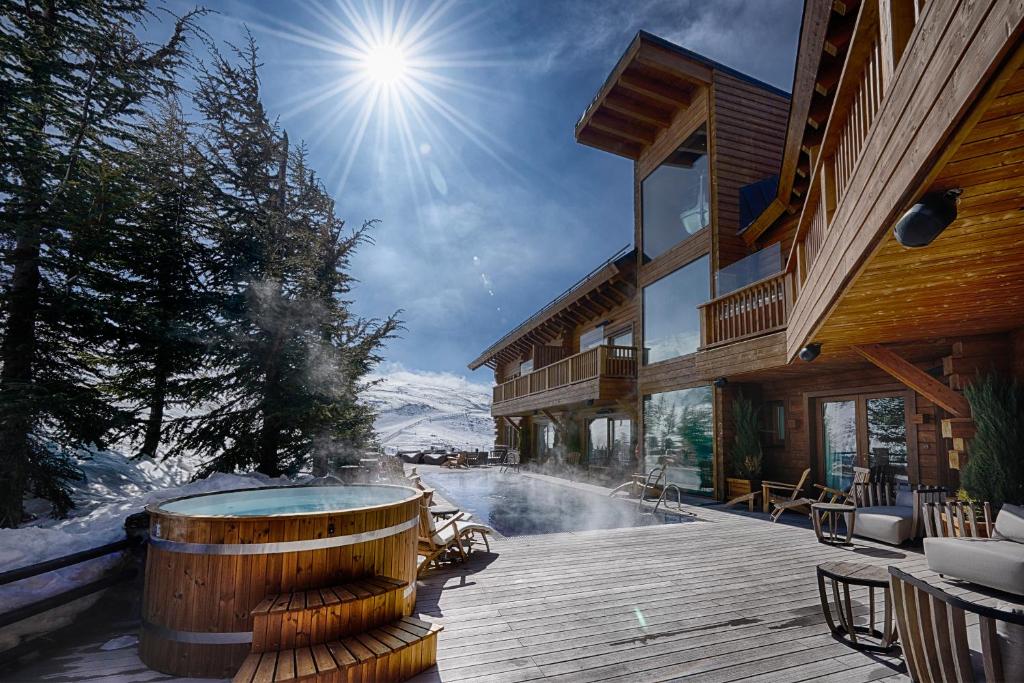 a hot tub on a deck next to a building at El Lodge, Ski & Spa in Sierra Nevada