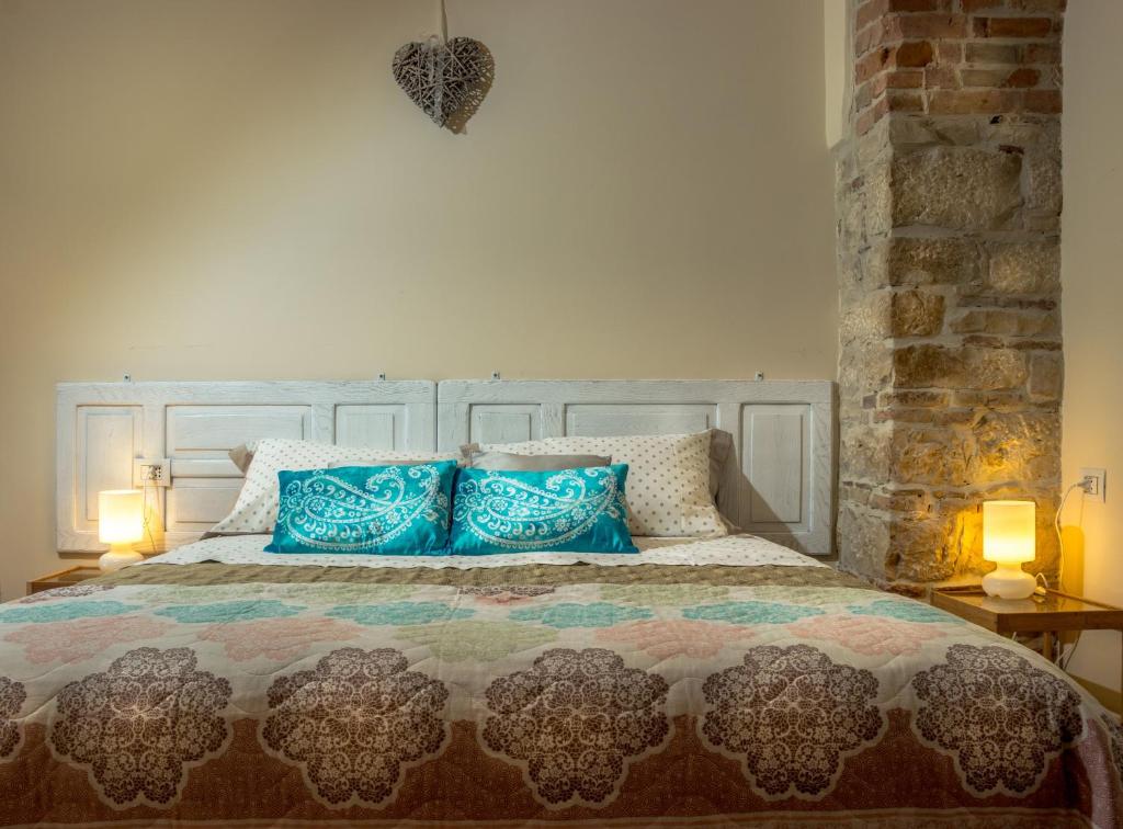ヴェノーザにあるA CASA 28 Bed&Breakfastのベッドルーム(青い枕の大型ベッド1台付)