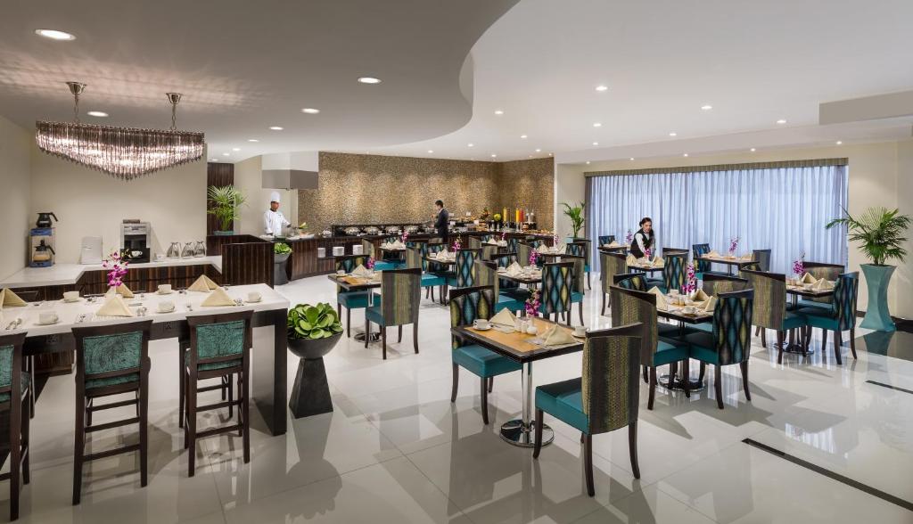 a restaurant with tables and chairs with people in the background at Savoy Crest Hotel Apartment - Bur Dubai in Dubai