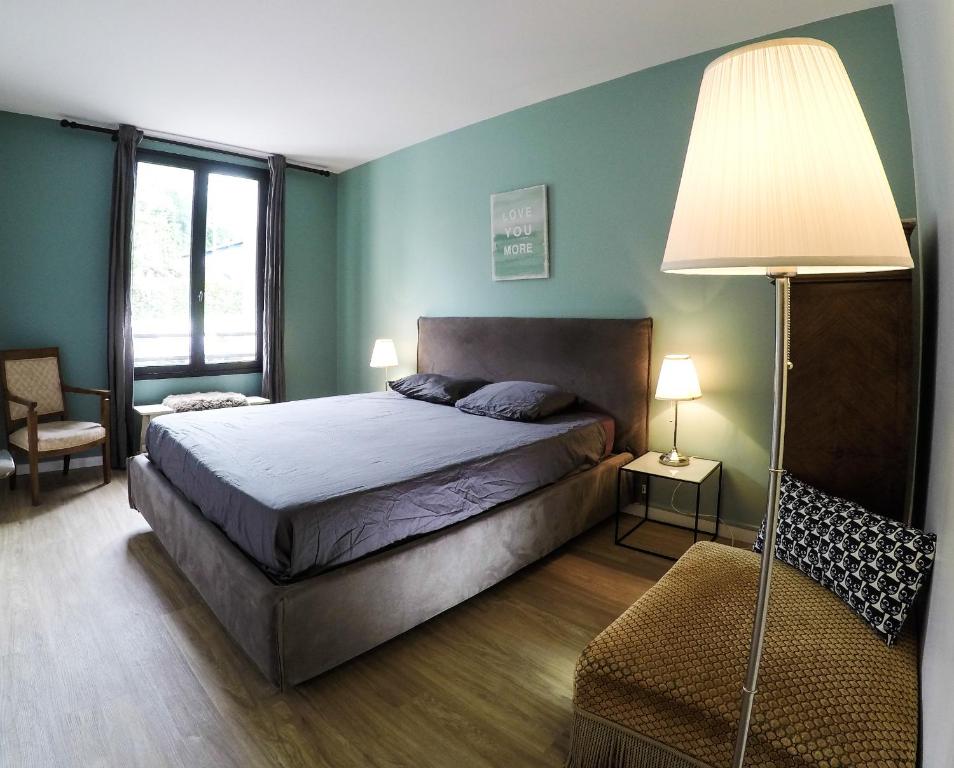 ein Schlafzimmer mit einem Bett, einer Lampe und einem Stuhl in der Unterkunft F3 - Guerin Locations Biarritz in Biarritz